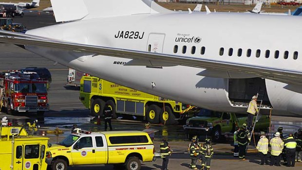 The Japan Airlines Boeing 787 Dreamliner is surrounded by emergency vehicles at Logan International Airport in Boston as a fire chief looks into the cargo hold.