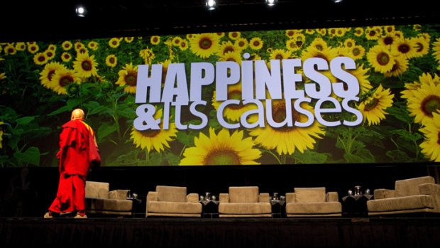 Buddhist monk, photographer, and author Matthieu Ricard leaves the stage at the happiness conference.