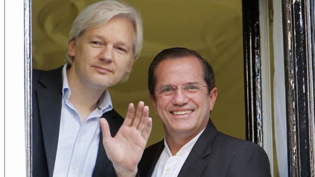 WikiLeaks founder Julian Assange waves from a window with Ecuador's Foreign Affairs Minister Ricardo Patino at Ecuador's embassy in central London.