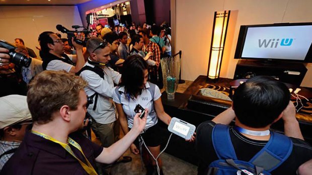 Crowds gather at the Nintendo booth during the Electronic Entertainment Expo where exhibitor Aurielle Rounsaville displays the Wii U.