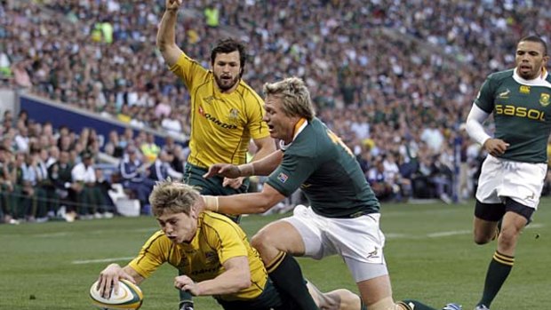 James O'Connor scores a try as South Africa's Jean de Villiers attempts to stop him.