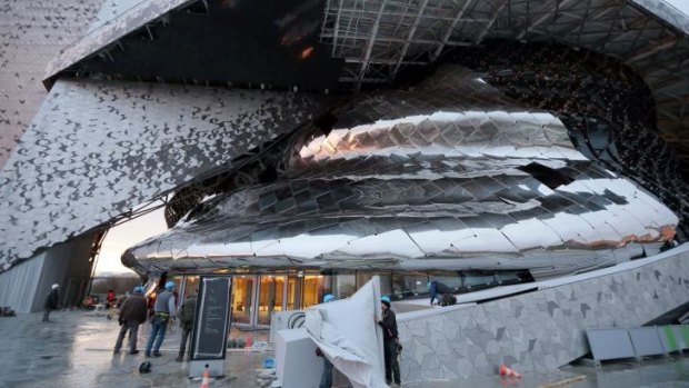 Metallic look ... Construction workers put the finishing touches on the new Philharmonie de Paris.