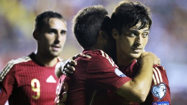 Spain's midfielder David Silva (R) celebrates with his teammates after scoring.