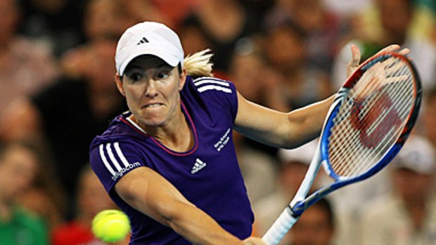 Justine Henin plays a backhand to Australian Alicia Molik in their clash at the Hopman Cup in Perth last night. Henin won the match 6-4, 6-4.
