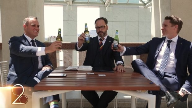 Liberal MPs Tim Wilson, left, and Andrew Hastie, right, hold up Coopers beer bottles in the video.