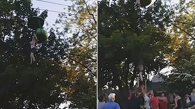 The girl dangling from the ride, and then falling into the arms of people standing below. 