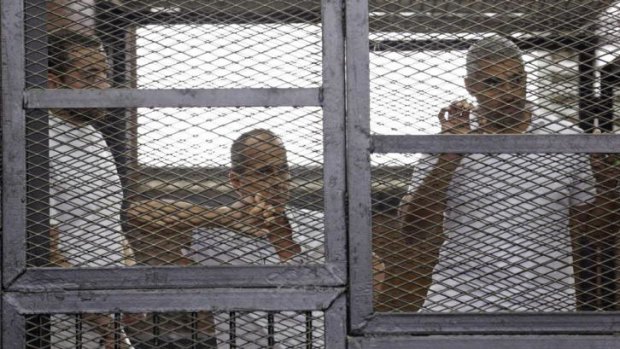 Al-Jazeera journalists Baher Mohamed, Peter Greste and Mohammed Fahmy behind bars in court in Cairo.