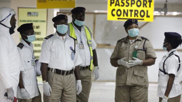 Nigeria health officials wait to screen passengers in Lagos.
