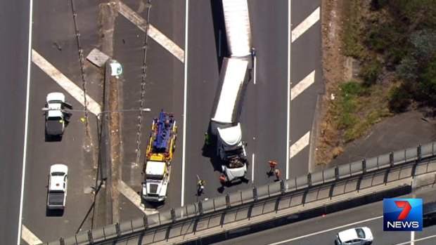 A truck is removed from an overpass on the Bruce Highway.