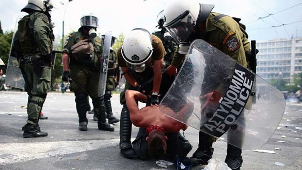 Riot police arrest a protester in Athens.