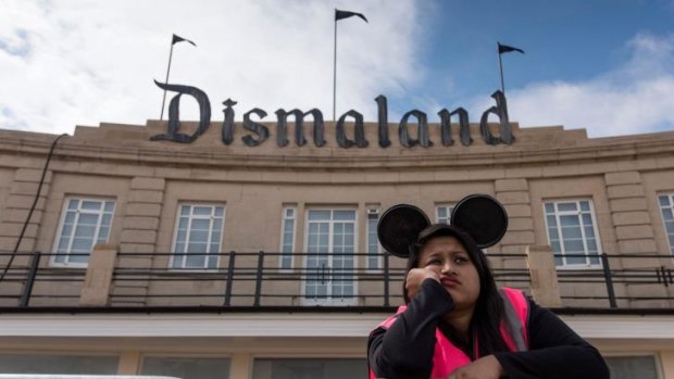 Gloomy ... a steward gets into the spirit of Banksy's new theme park.