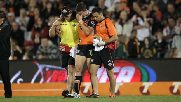 Unlucky break: Tim Moltzen is escorted off the ground after suffering a season-ending knee injury against the Broncos.