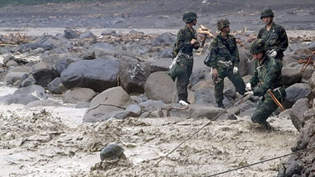 Taiwan Military News Agency released this shot of  troops crossing a river to search for survivors.