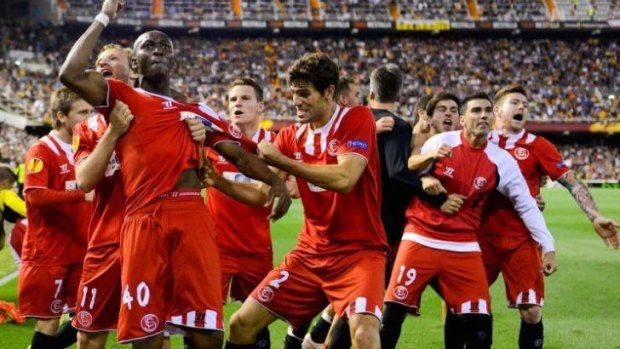 Sevilla's players celebrate their victory on away goals.