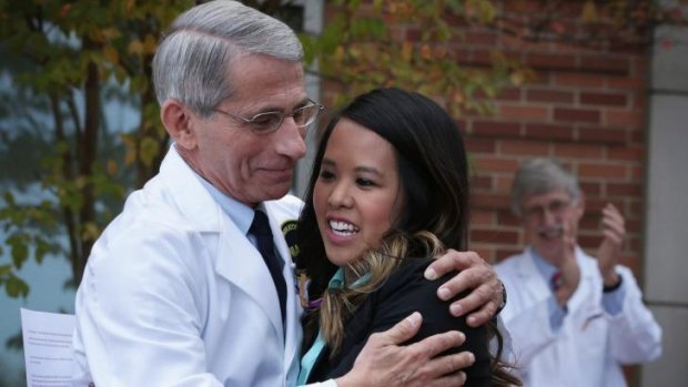 Director of the National Institute of Allergy and Infectious Diseases Anthony Fauci (left) hugs Nina Pham (2nd L), the nurse who was infected with Ebola from treating patient Thomas Eric Duncan and has now been declared free of the virus after treatment.
