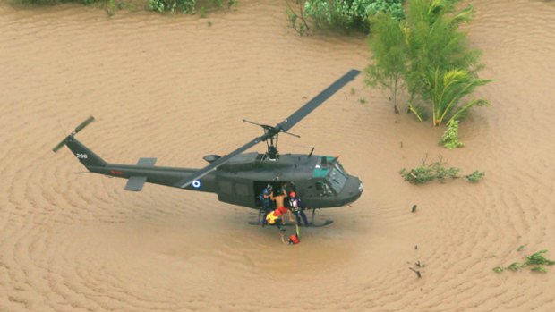 Rescuers use a helicopter to save people from floodwaters.