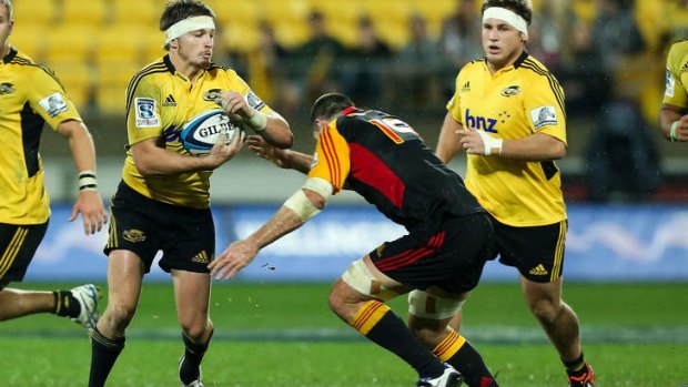 Beauden Barrett of the Hurricanes is tackled by Nick Crosswell of the Chiefs.