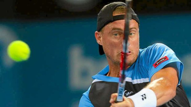 Young and old: Lleyton Hewitt hits a return during his first round match against teenage compatriot Thanasi Kokkinakis at the Brisbane International.