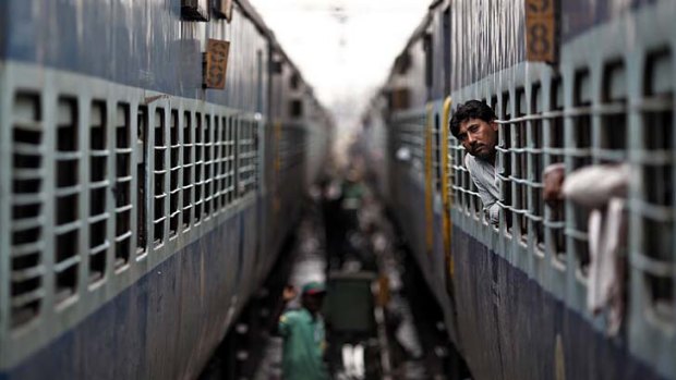 World's largest power shortage ... a passenger looks through the window of a train as he waits for electricity to be restored at a railway station in New Delhi.