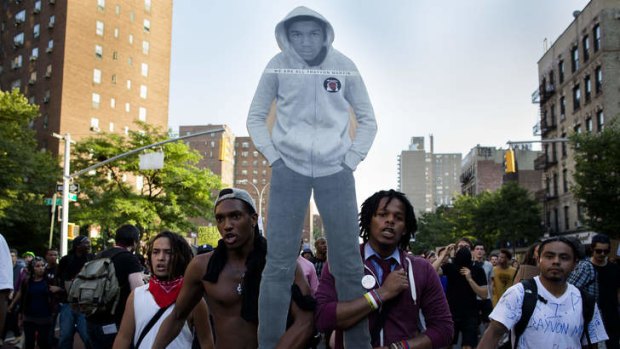 Demonstrators march through the Lower East Side neighborhood of Manhattan in New York holding a cut-out of Trayvon Martin during a protest against the acquittal of neighborhood watch member George Zimmerman.