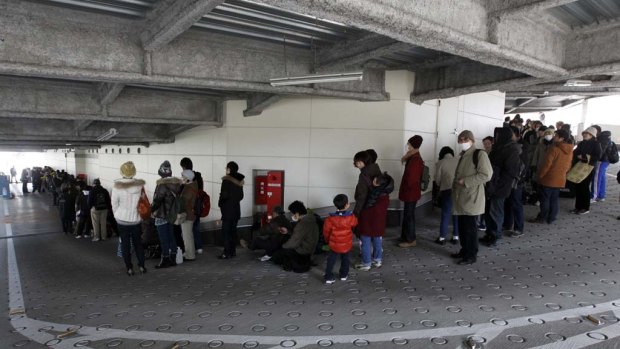 People line up to buy food at a supermarket that had been temporarily closed after the  earthquake and tsunami hit Sendai.