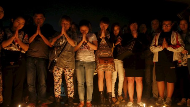 Local residents pray at a candlelight vigil to pay their respect to the victims of the sunken cruise ship on the Yangtze River, at a public square in Jianli, Hubei province, China.