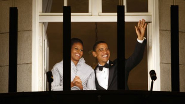 ’’Obama, you won it, now earn it’’ ... Mr Obama, beside his wife, Michelle, waves to the crowd from the balcony of the Grand Hotel in Oslo.