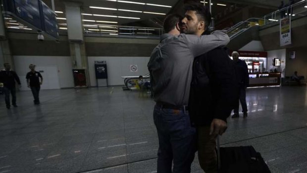 'Security threat': Journalist Glenn Greenwald, left,  embraces his partner David Miranda upon his arrival at Rio de Janeiro's International Airport.