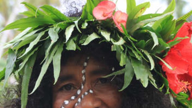 A Logeia women in floral head dress.