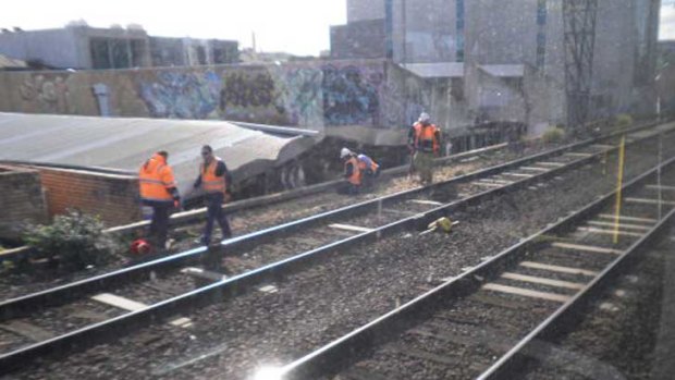Workers clear debris from the railway tracks at Richmond.