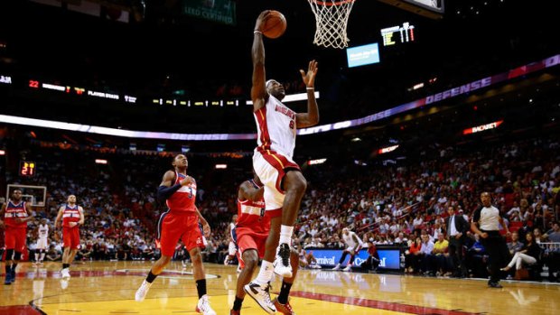 LeBron James lays the ball up in front of Bradley Beal  of the Washington Wizards.