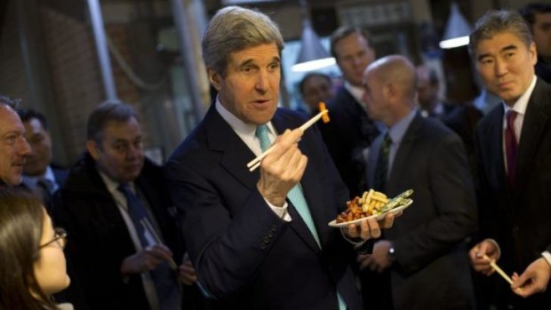 US Secretary of State John Kerry samples food during a tour of the Tong-in Market in Seoul.