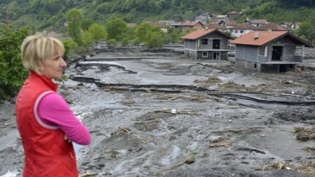 A resident overlooks the damage done by a landslide at the Bosnian village of Topcic Polje. Bosnia, Serbia and Croatia have been hit by the worst flooding in more than 100 years.