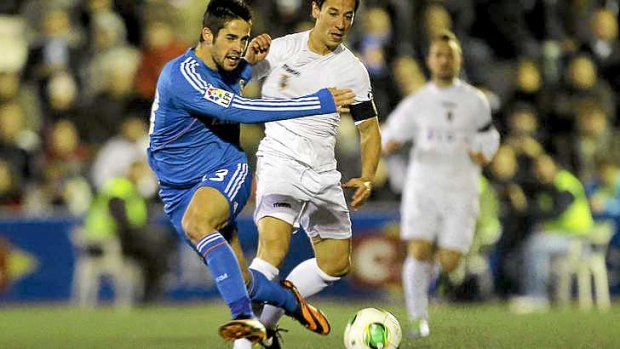 Real Madrid's midfielder Isco gets a pass away despite the attention of Olimpic's midfielder Rifaterra.