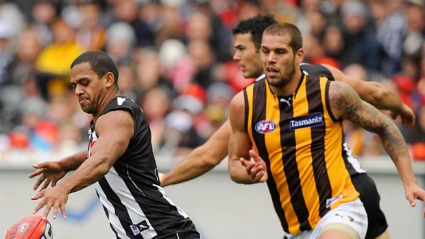 Leading from the back: Magpie Leon Davis burns off Hawk Lance Franklin as he charges out of defence.