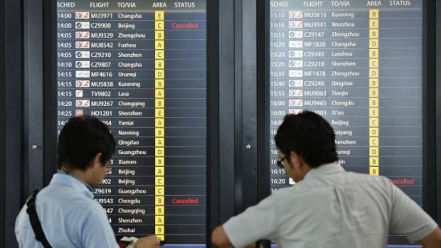 Passengers at Hongqiao International Airport in Shanghai look at flight information this week.