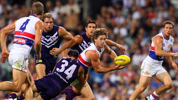 Nick Lower of the Dockers tackles Callan Ward  of the Bulldogs during their round five match.