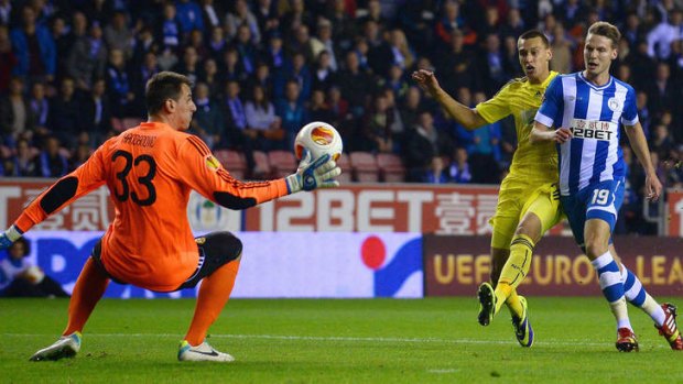 NK Maribor's goalkeeper Jasmin Handanovic saves a shot from Wigan Athletic's mid-fielder Nick Powell.