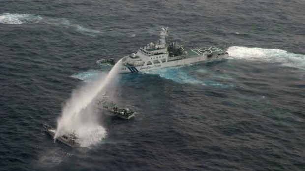 Shot over the bows &#8230; a Japanese Coast Guard patrol boat, right, fires water cannons at a Taiwanese fishing boat carrying protesters, bottom left, while a Taiwanese Coast Guard vessel, centre, intercedes.