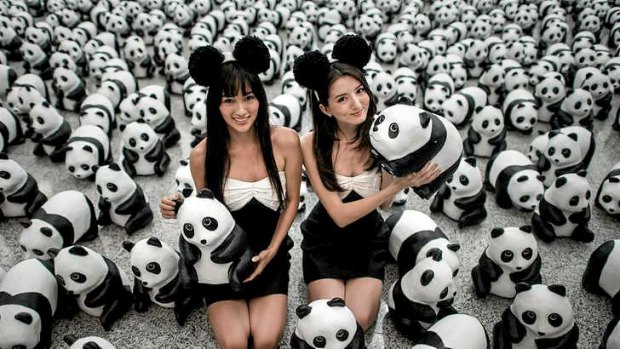 Models pose with some of the 1,600 papier-mache pandas displayed at Hong Kong's international airport.