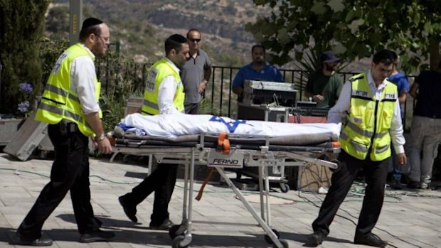 Israeli Zaka organisation  volunteers walk with the body of Gilad Shaer, 16,  during his funeral ceremony at his hometown on Talmon, West Bank on July 1.