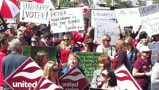 Hundreds of education staff protest outside parliament but Education Minister stays firm on cuts.
