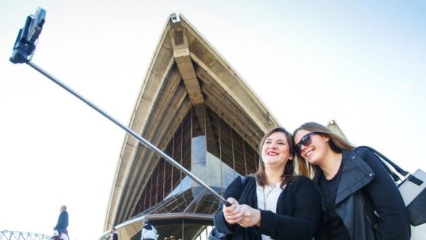 Anna Stahl, from Germany, and Jennifer Himryd, from Sweden, use a selfie stick to capture the moment on the steps of the Sydney Opera House.