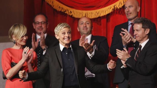 Ellen DeGeneres smiles as her family and friends, including wife Portia de Rossi (left), applaud her entrance at the Mark Twain Prize ceremony in Washington.