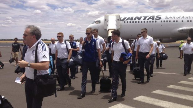 Red centre of attention: Stuart Broad and James Anderson lead the England squad off the tarmac on their arrival in Alice Springs on Tuesday.