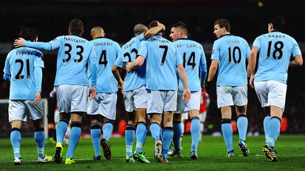 Manchester City players congratulate James Milner (7) after he scored against Arsenal.