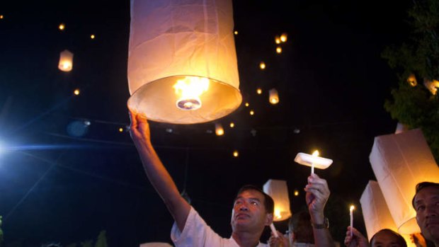 Chiang Mai residents attend a candle-light and lantern-floating vigil to urge non-violence in the lead-up to today's election.