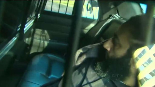 Denies charges: Raed Jaser arrives at the Toronto court in the back of a police car.