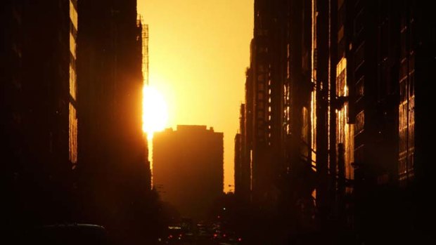 The sun sets  over the west side of New York City, known as Manhattanhenge