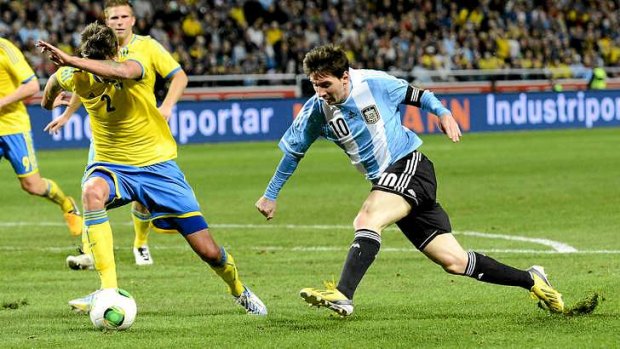 Argentina's striker and  captain Lionel Messi beats  Sweden defender Mikael Lustig during the international friendly in Stockholm.